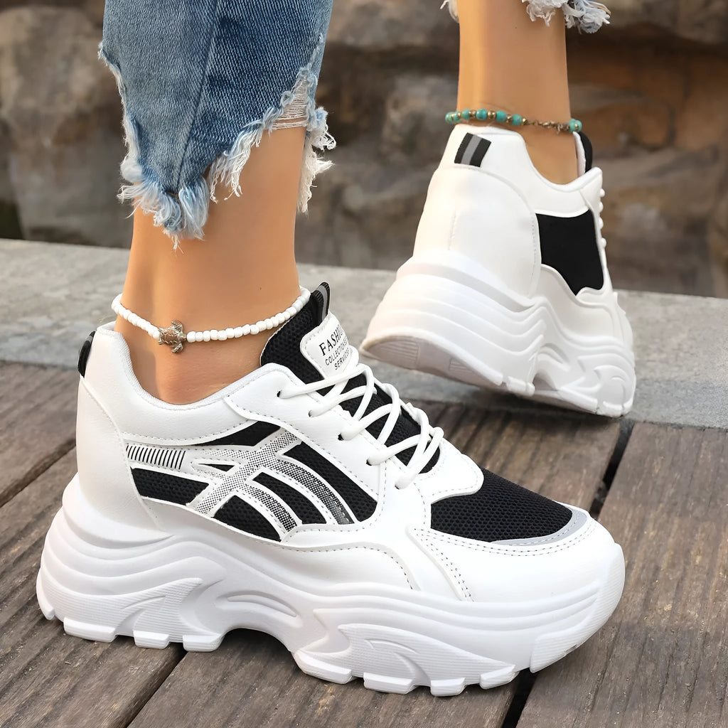 Women's platform wedge sneakers in black or white with mesh lining, rubber sole, front lace-up, round toe, and sewing thread detail.