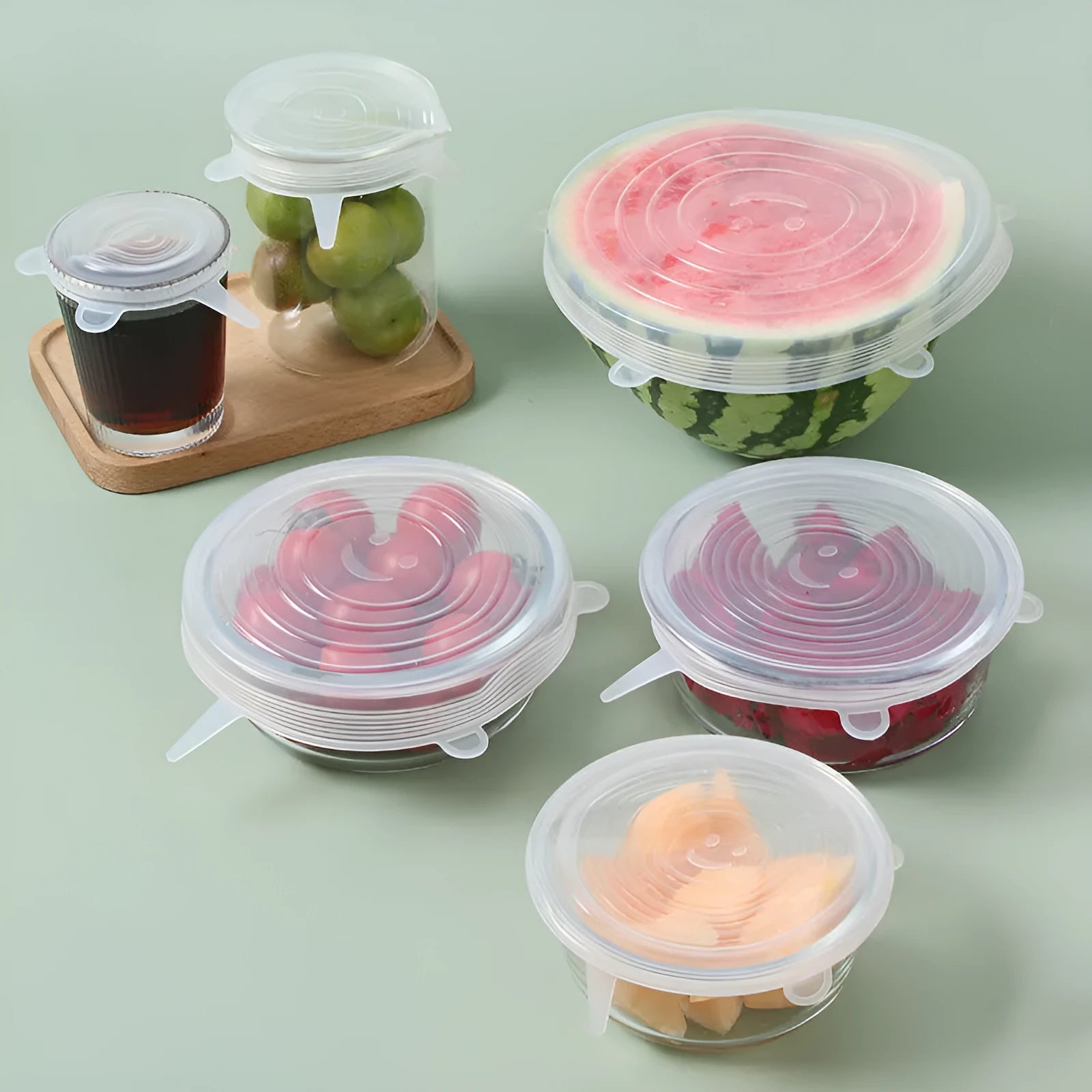Set of six colourful silicone stretch food covers in different sizes on a kitchen counter.