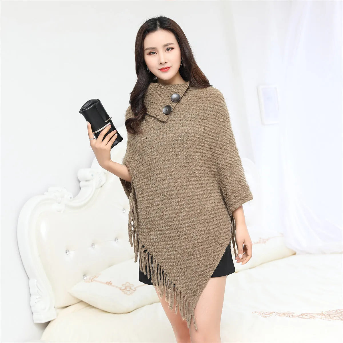 Sleeveless dotted-pattern cloak shawl in acrylic knitwear, shown in apricot colour.