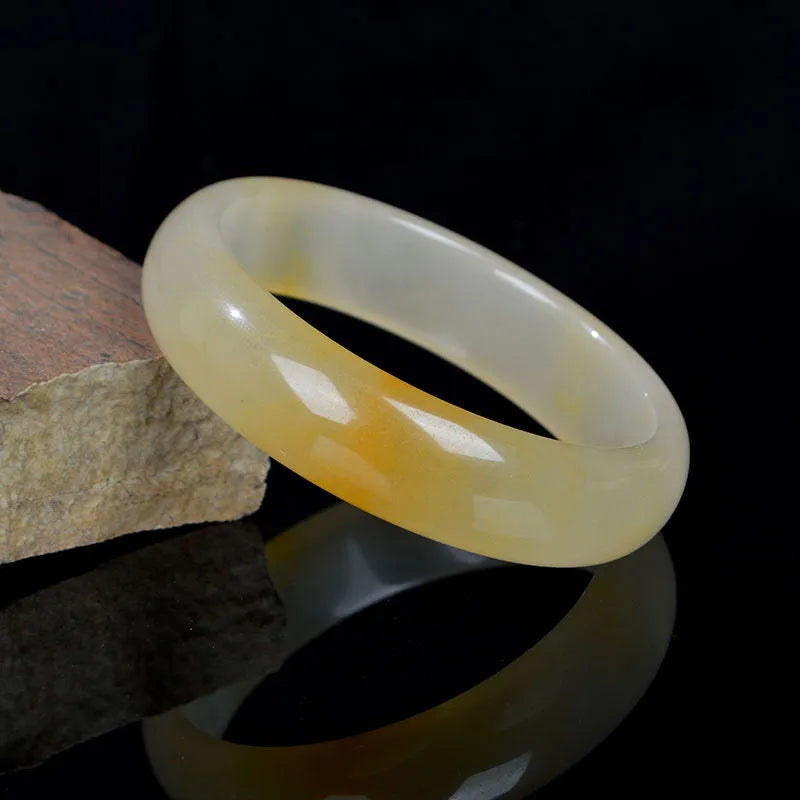 A polished natural light jade bracelet in a traditional Chinese style for women.