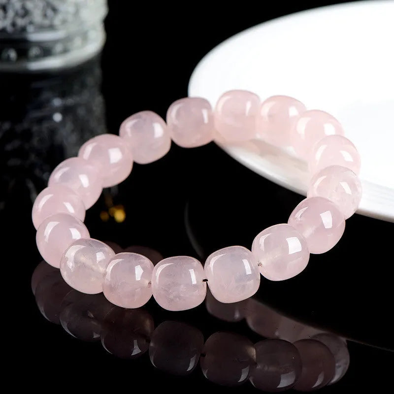 Pink crystal barrel bead bracelet with geometric design on a wrist.