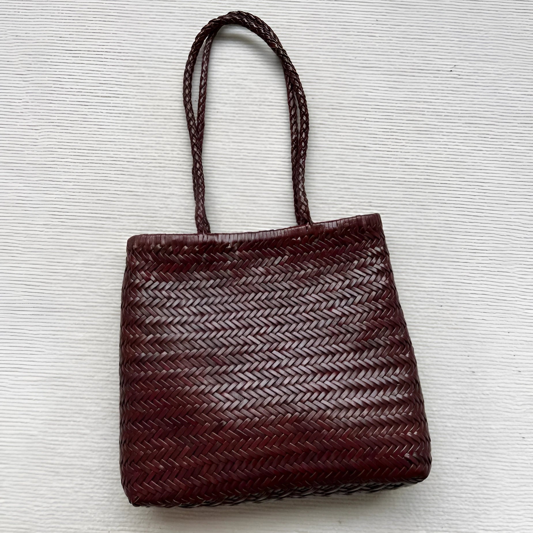 Brown handmade woven leather tote bag with a front pocket and polyester lining.