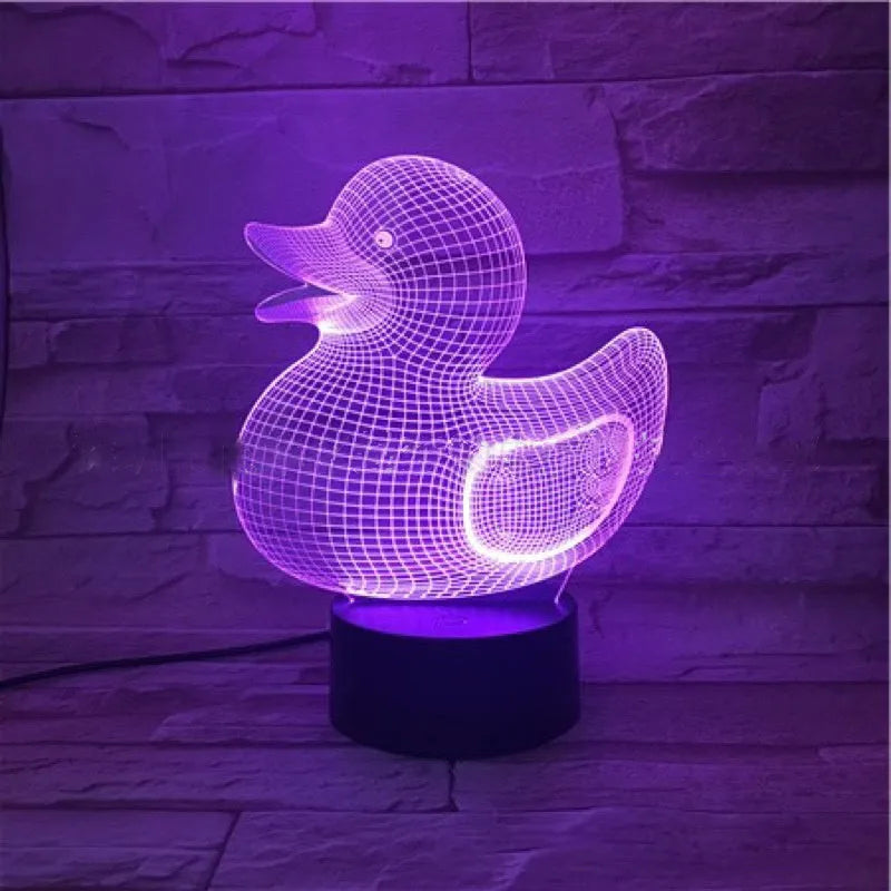 Little yellow duck 3D night light with remote control on a table, showing its colourful LED illumination.