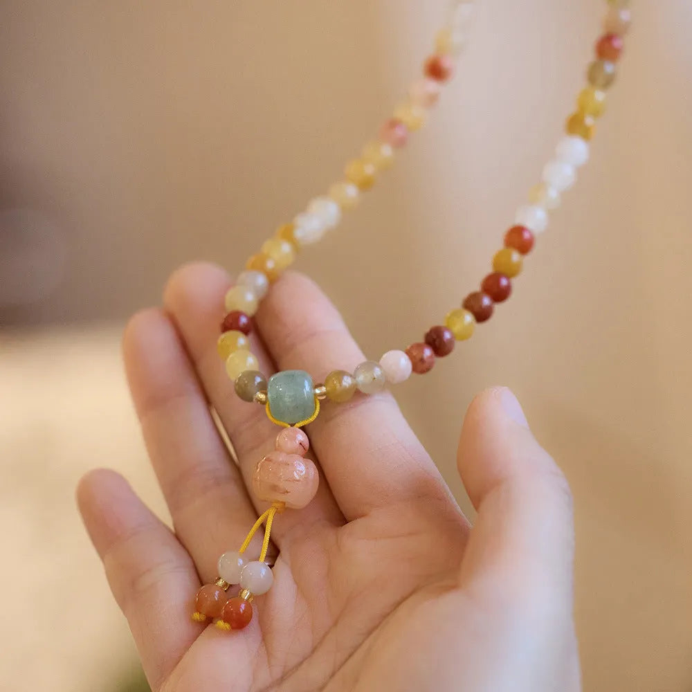 Women's Jinsi Jade bracelet with three-circle pumpkin design and tassels on a wrist