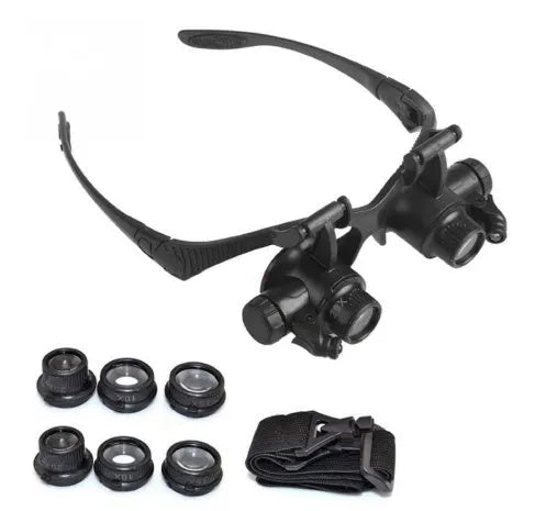 Black hands-free LED magnifying glasses with interchangeable lenses on a headband for watch repair.