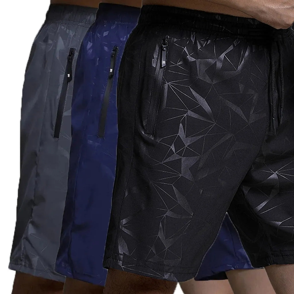 Man wearing loose grey printed polyester sports shorts on a beach.