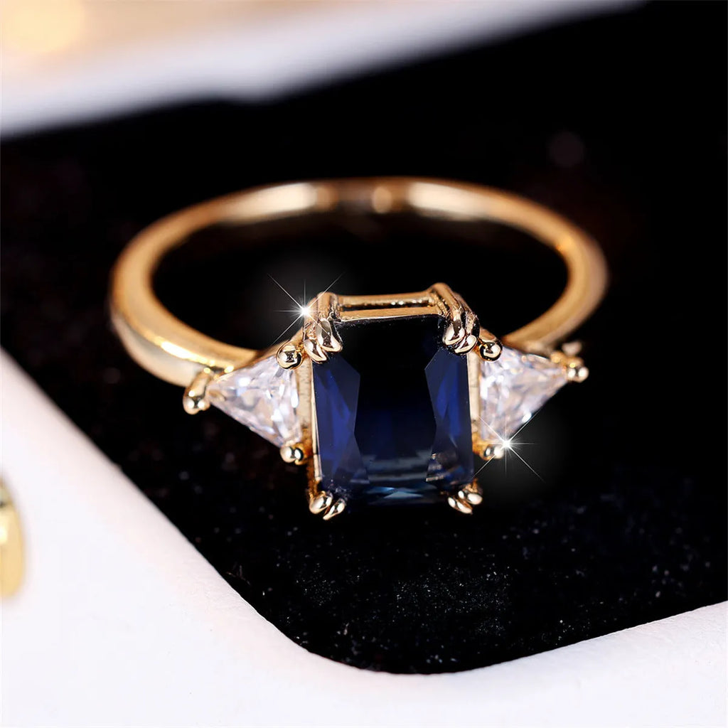 Rectangular copper ring with gold sapphire blue finish shown on model finger