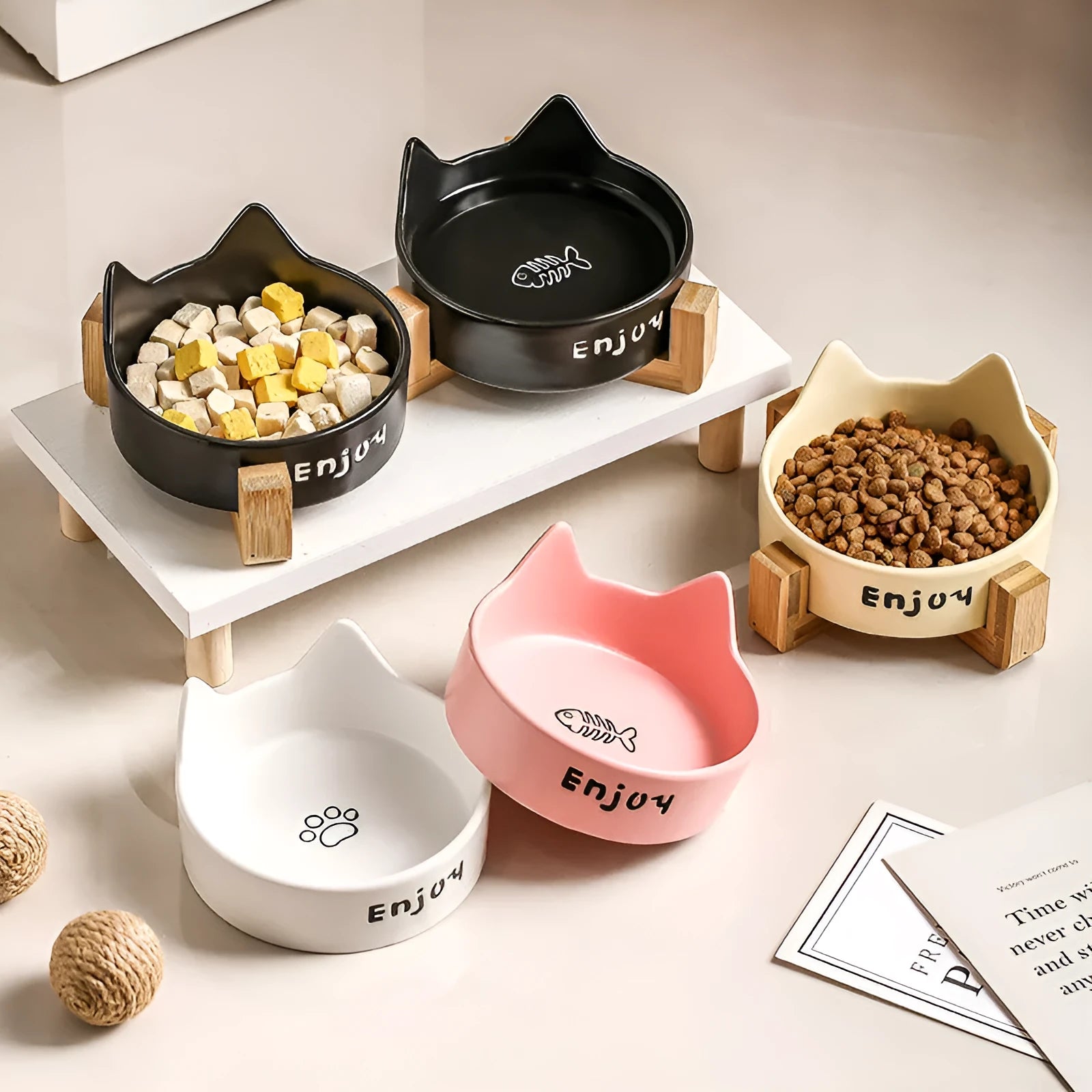 Porcelain cat bowl with cat ear handles in a wooden anti-tumble frame, showing paw print design.