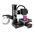 K9 New Mini 3D Printer on a desktop with a small printed toy model next to it.