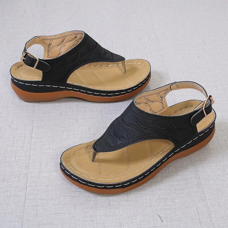 Women's red wedge heel sandals with an adjustable buckle strap on a plain background.