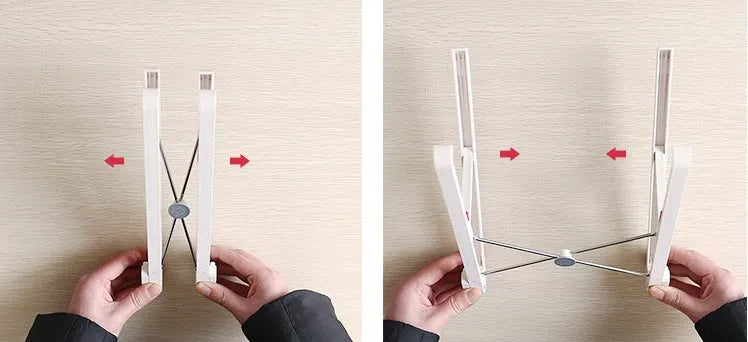 White foldable laptop bracket with heat sink base on a desk.