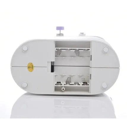 Miniature white and grey electric household sewing machine with thread spool and power cord.