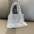 Silver handbag decorated with shiny rhinestones, made from cotton thread with one open pocket.
