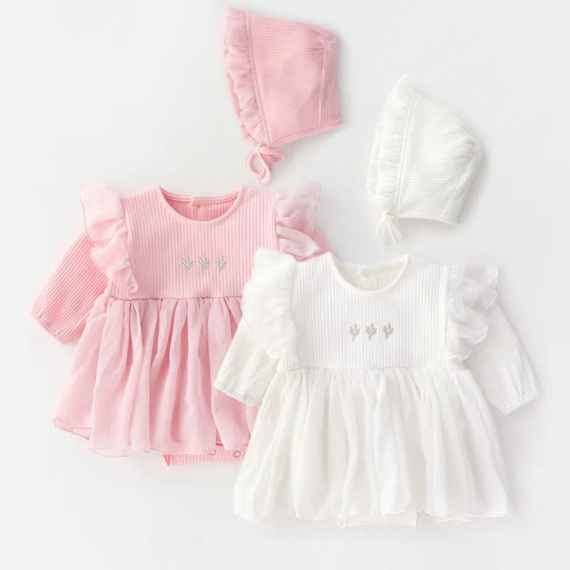 A baby girl wearing a fluffy cotton princess dress in pink, for a christening or birthday.