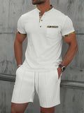 Men's grey waffle weave zippered polo collar short sleeve top and matching shorts suit set laid flat.