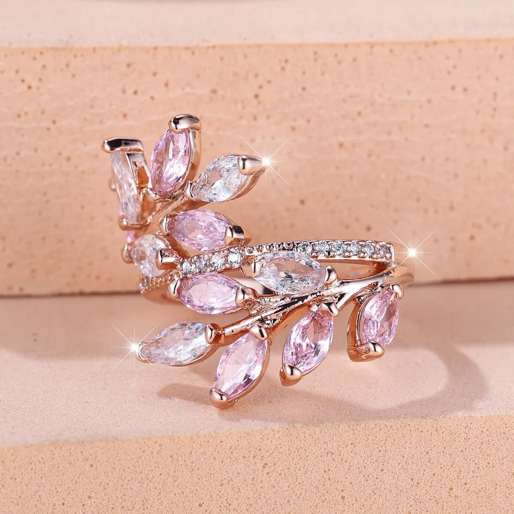 Adjustable copper leaf-shaped ring with zircon stone accents on a hand.