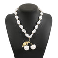 Gold-coloured adjustable necklace with a fruit-shaped pendant on a pearl-style chain.