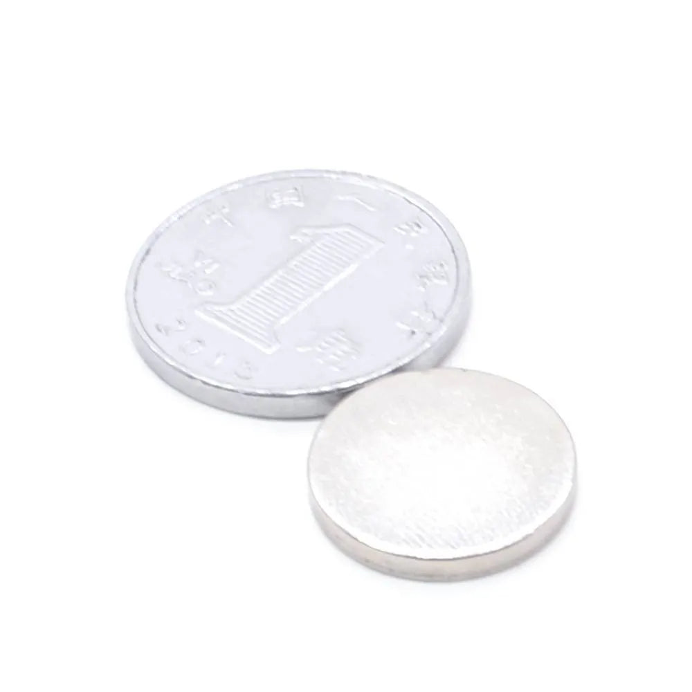 Silver neodymium magnet disc 14x2mm on plain background