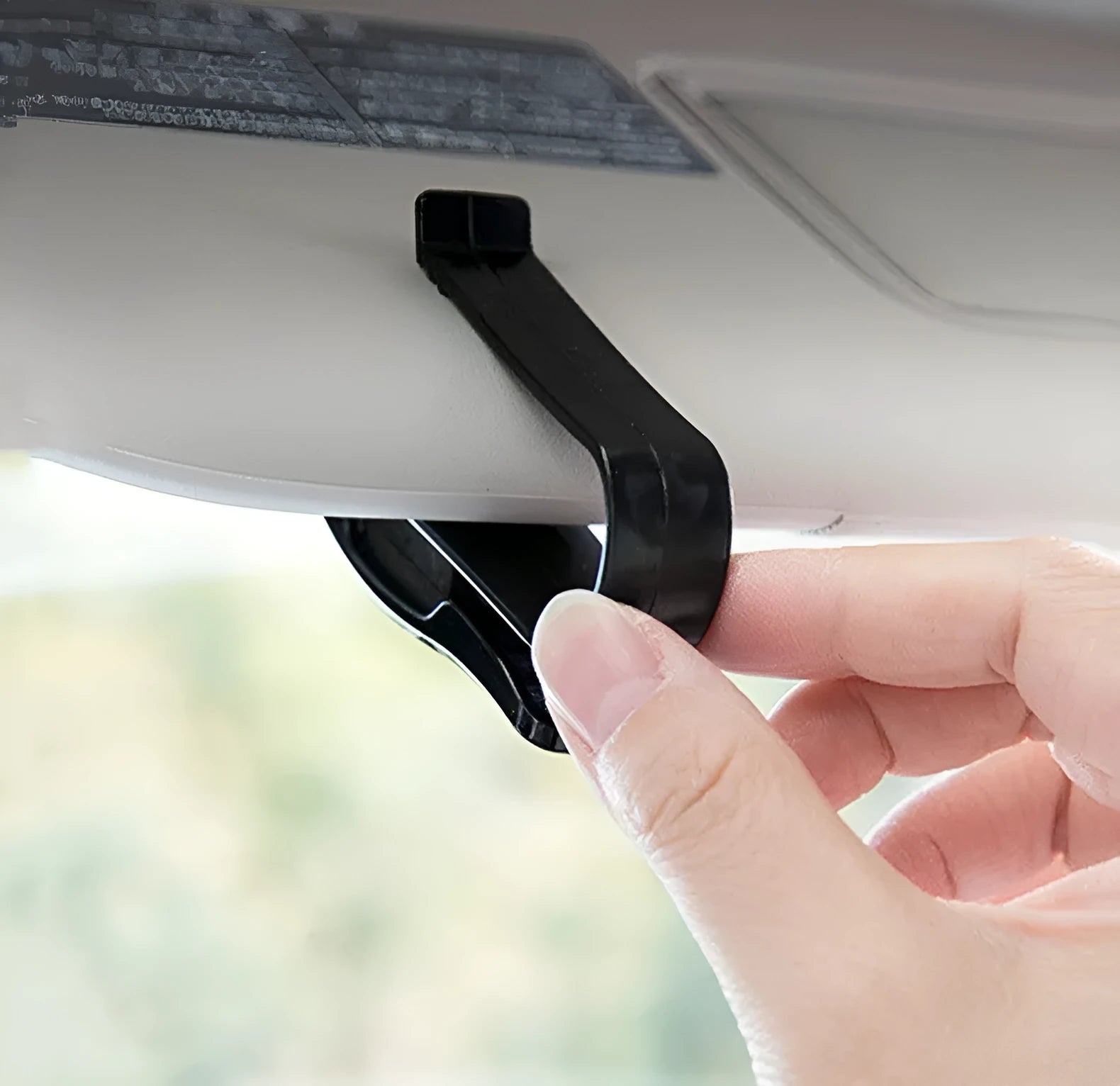 Black plastic clip for car sunshade to hold sunglasses and tickets.