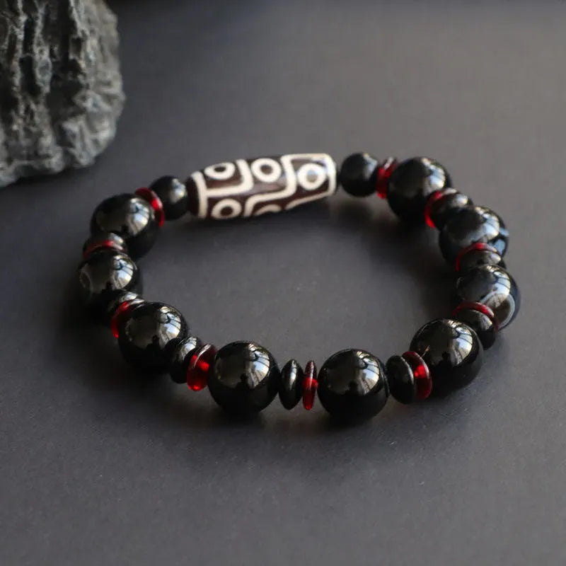 Hand-woven black agate dzi bead bracelet with 11mm geometry beads on a wrist.