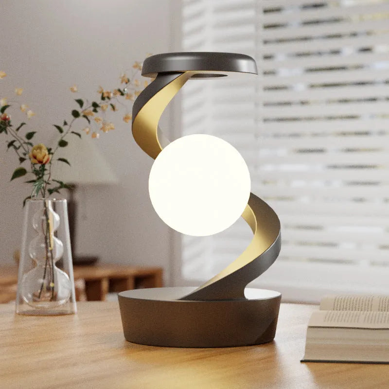 Rotating moon desk lamp with wireless charger in grey on a bedside table