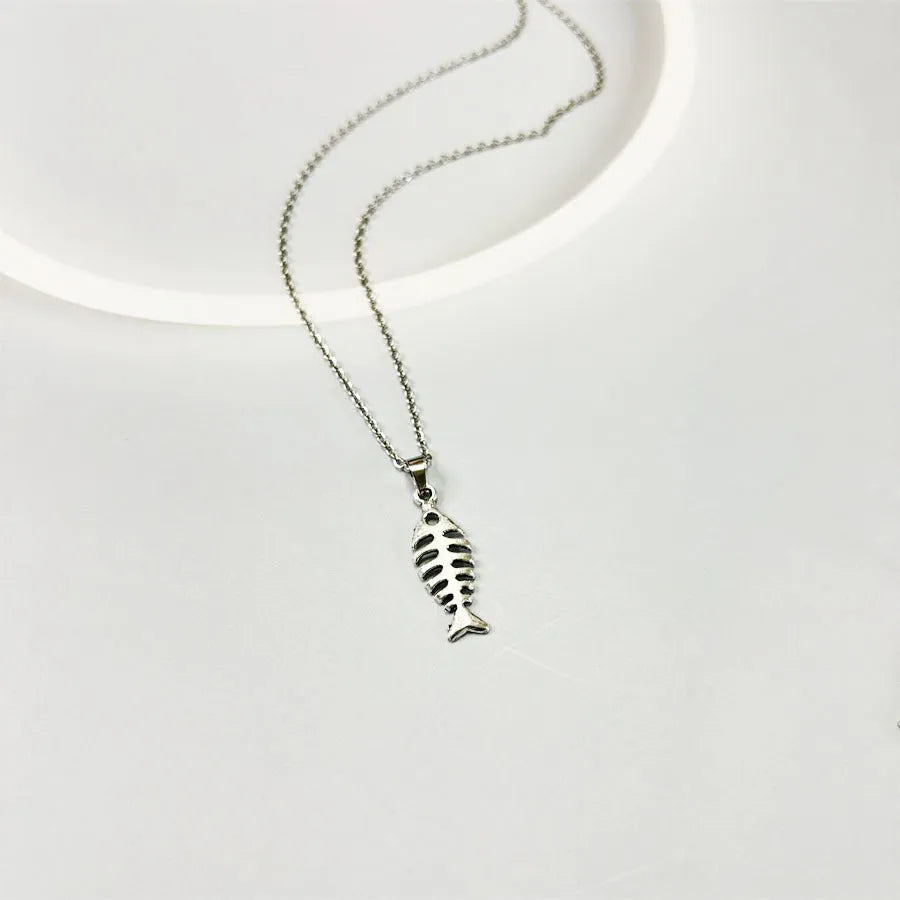 Women's fishbone pendant necklace and matching earrings set with adjustable chain on retro background