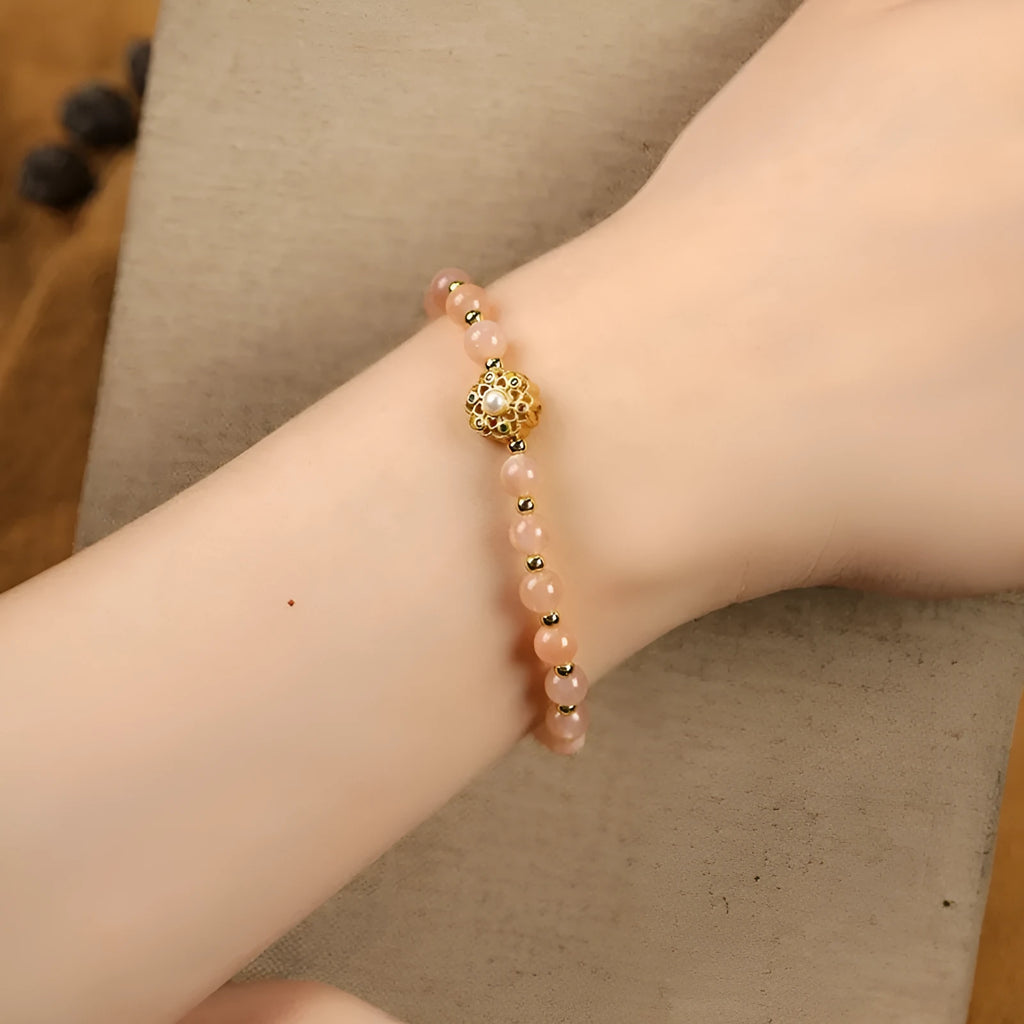 Gray moonstone and pink sunstone crystal bracelet with hand-woven cord and peach blossom quartz charms.
