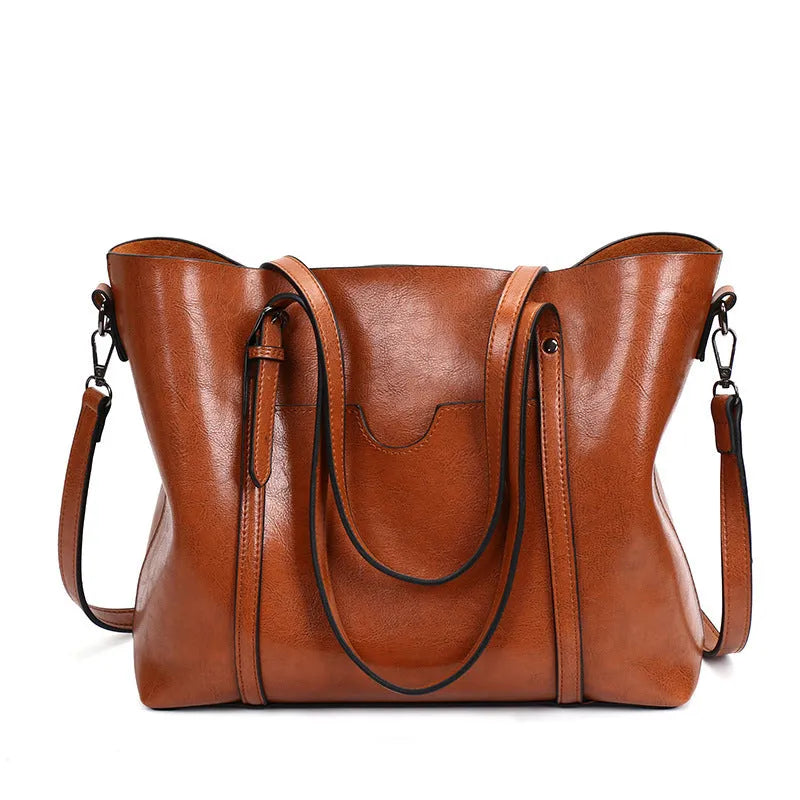 Brown retro-style PU leather messenger bag for women, shown with an A4 magazine inside to illustrate its large capacity.