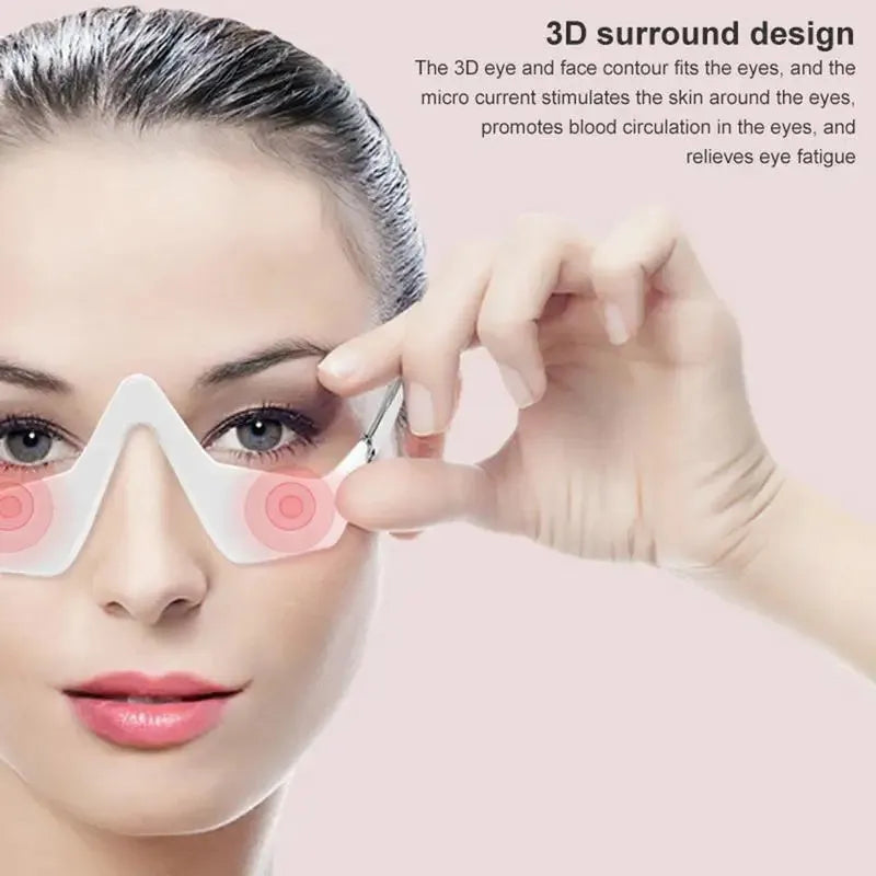 Pink and white 3D micro-current eye massager with glasses-style design on a stand.