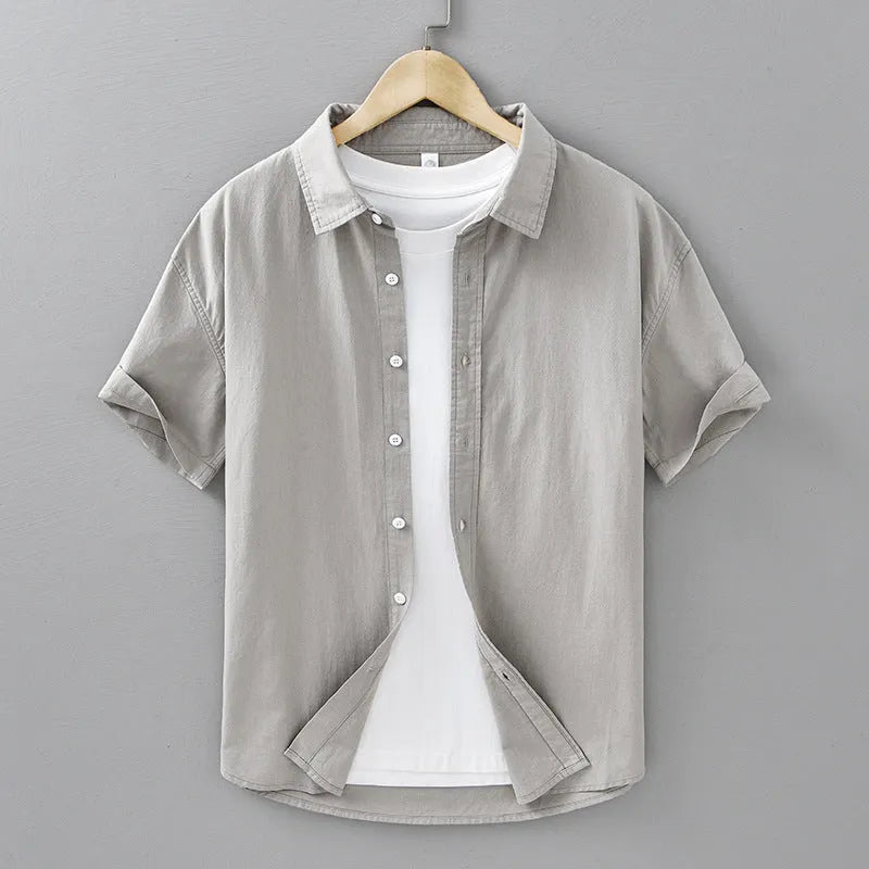 Men's light grey loose fit short-sleeved cotton cardigan shirt on a hanger.
