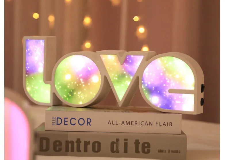 Rainbow coloured plastic LED LOVE light decoration on a desk.
