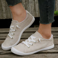 Women's creamy white low-top fabric casual sneakers with a rubber sole on a neutral background.
