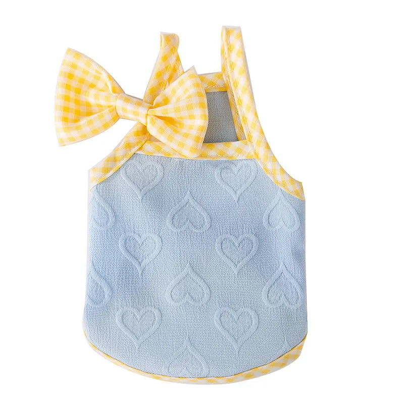 Small dog wearing a blue elastic suspenders vest with a heart-texture bow.