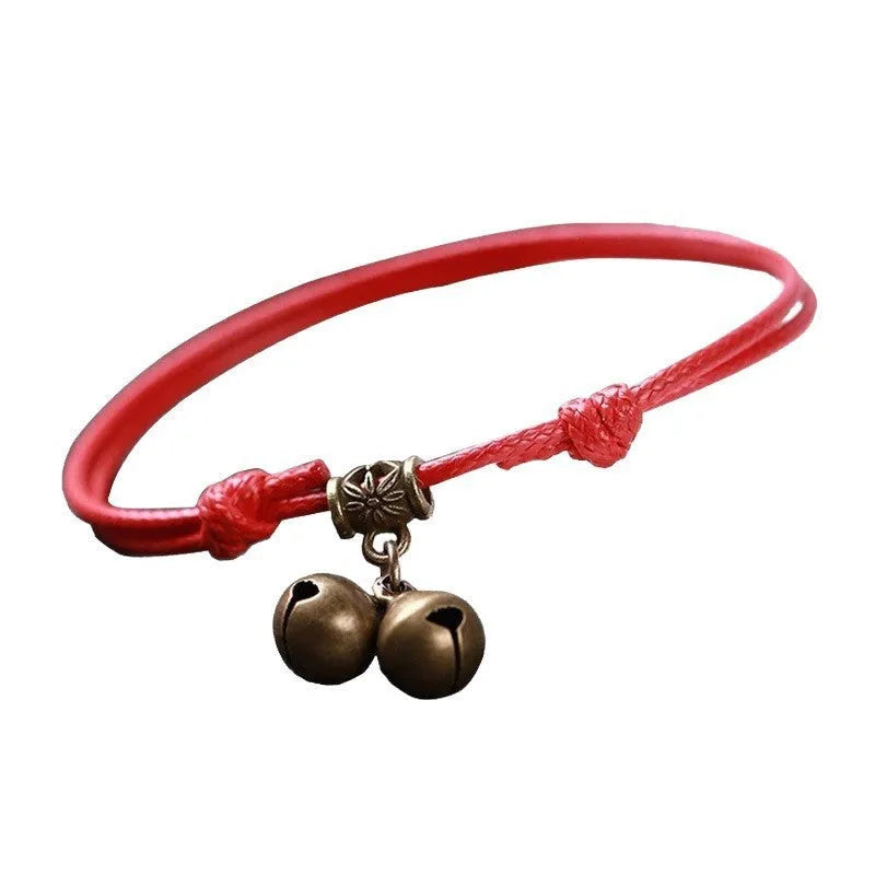 Adjustable nylon rope dog collar with brass buckle on a black background, showing the brass bell option.