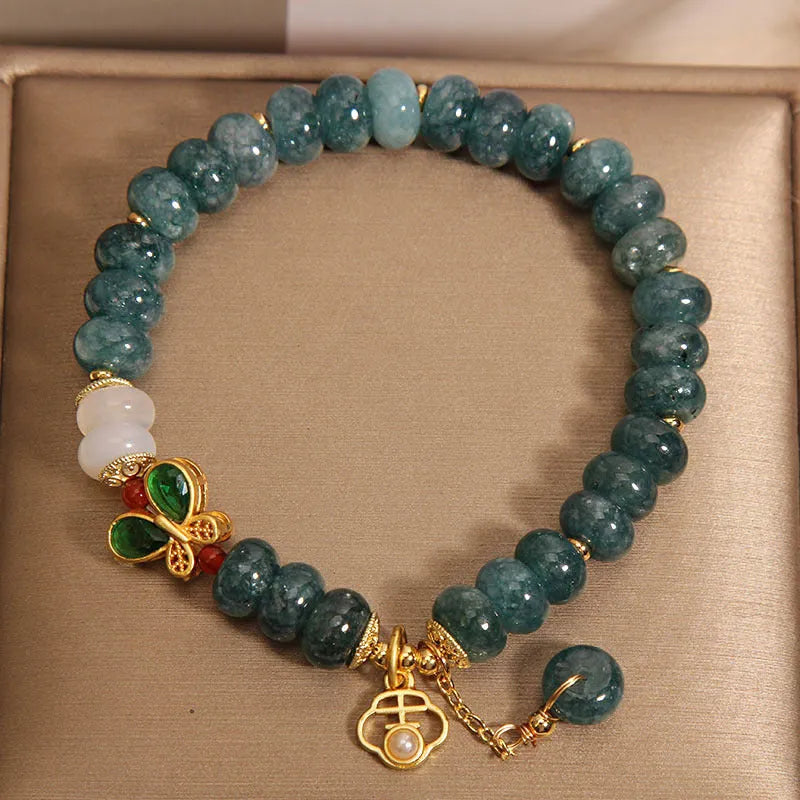 Women's blue water jade and white agate abacus bead bracelet with rhinestones and a butterfly charm on an alloy chain.