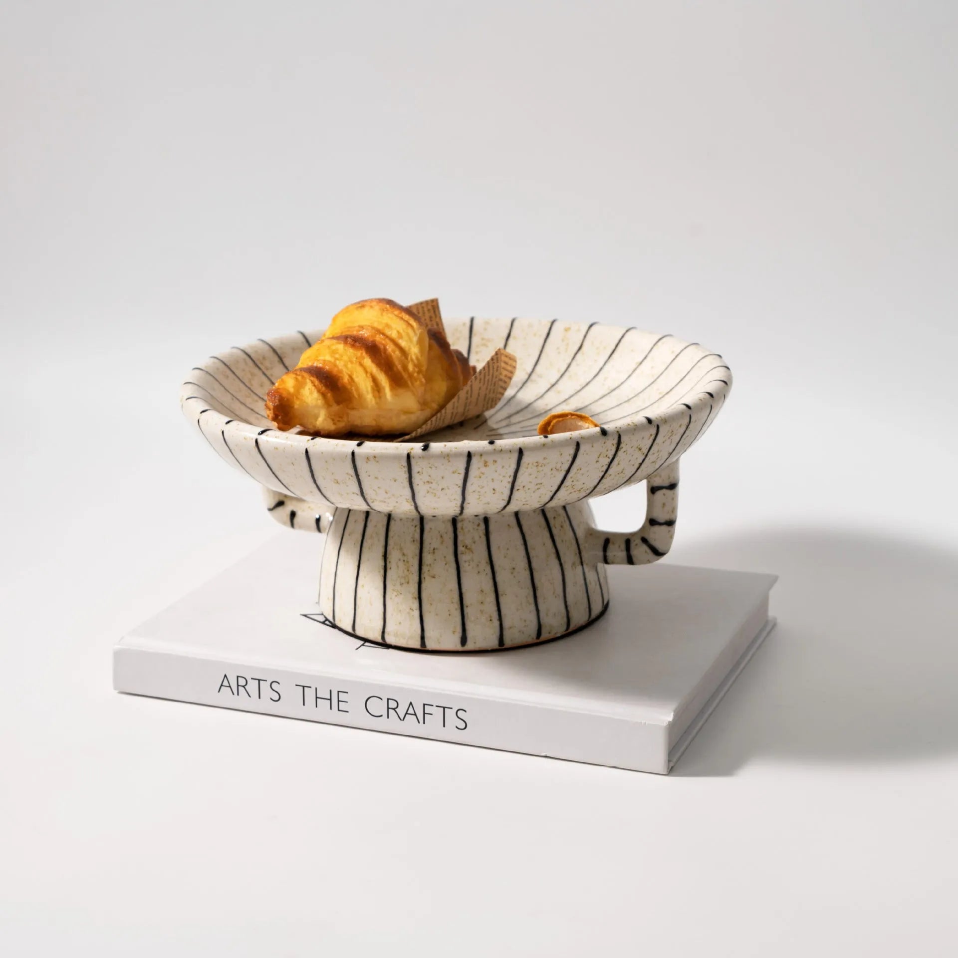 Black and white striped synthetic resin fruit plate on a table.