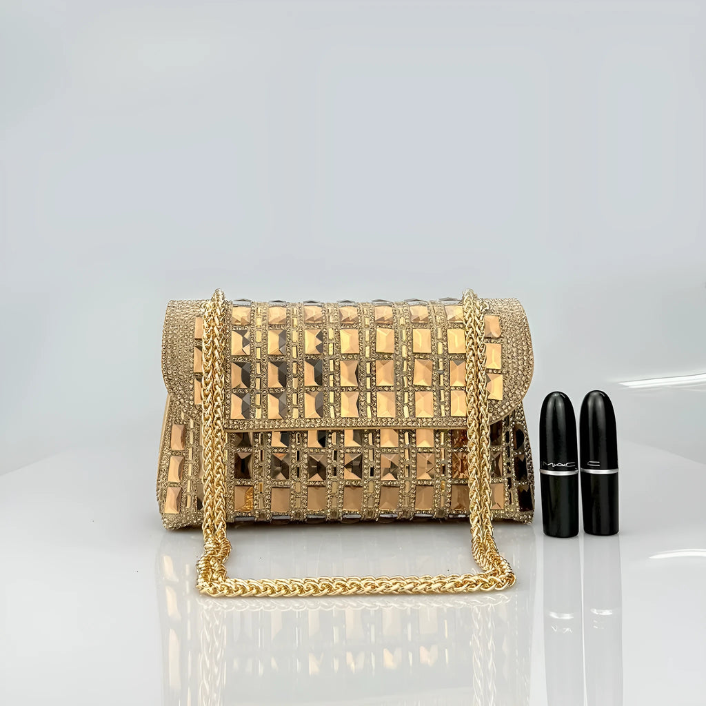 Silver rhinestone chain clutch bag with square shape and internal phone pocket on a table.