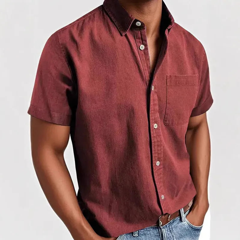 Man wearing a solid colour short-sleeved shirt with a polo collar and a single chest pocket.