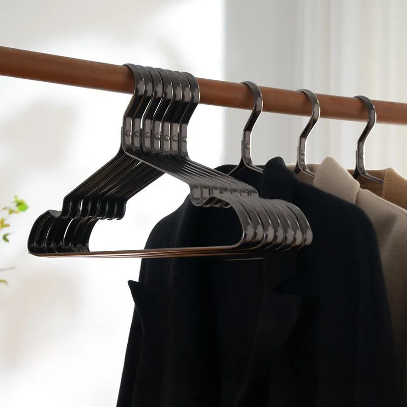 Modern elegant black clothes hanger with non-slip surface on a white background.
