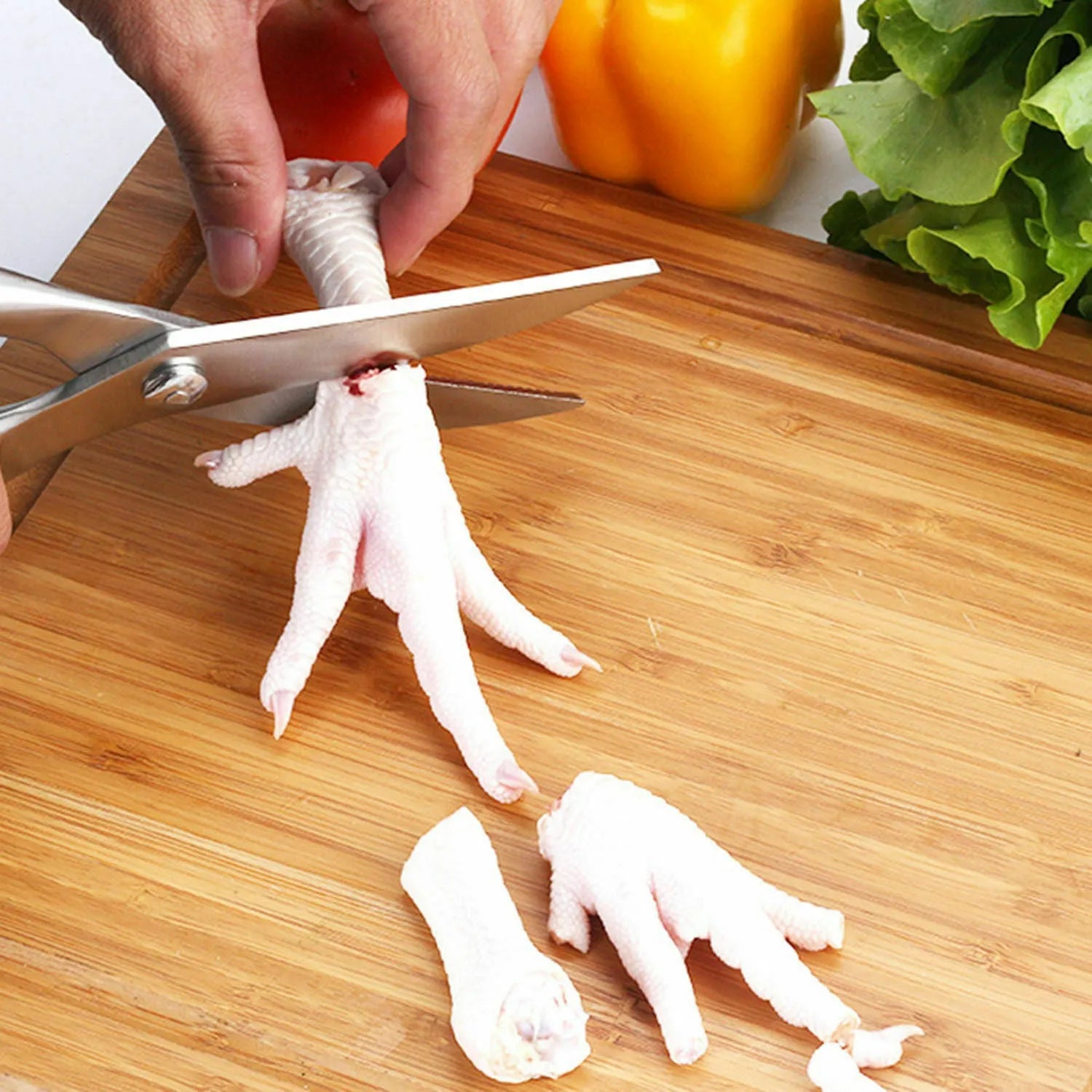 Silver stainless steel poultry shears 9.8 inch with serrated blade and bone notch on cutting board