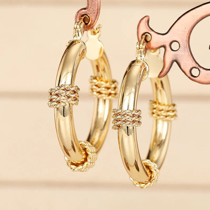 Geometric women's earrings made of copper in a gold finish, featuring a ring and line design.