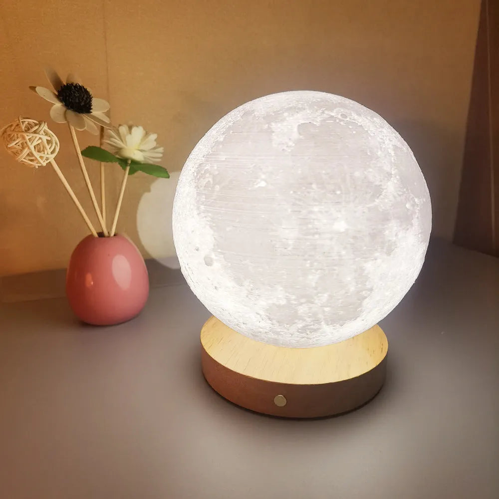Rotating sleeping moon night lamp on wooden base showing three-colour light options.