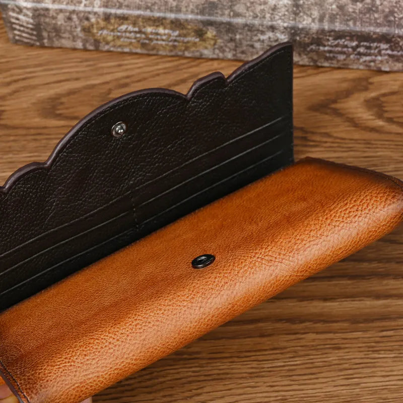 Retro brown Chinese floral embossed tri-fold women's leather wallet open to show compartments.