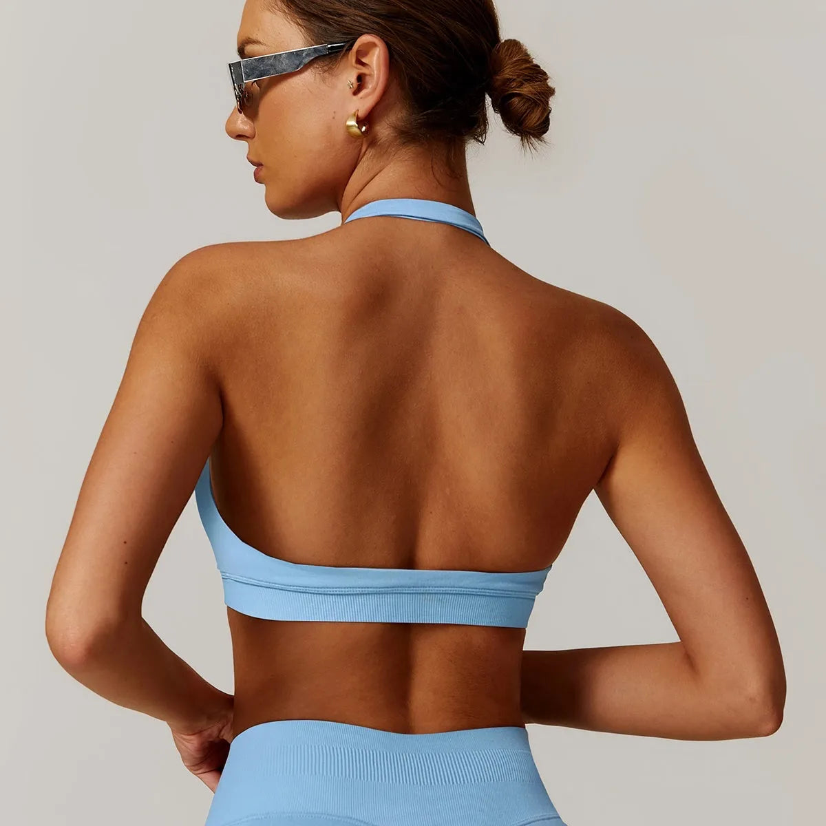 Women's black halter yoga bra with removable chest pad on a mannequin