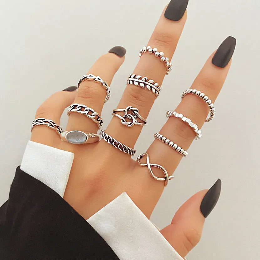 Geometric alloy ring with butterfly and snake motifs in retro style on finger