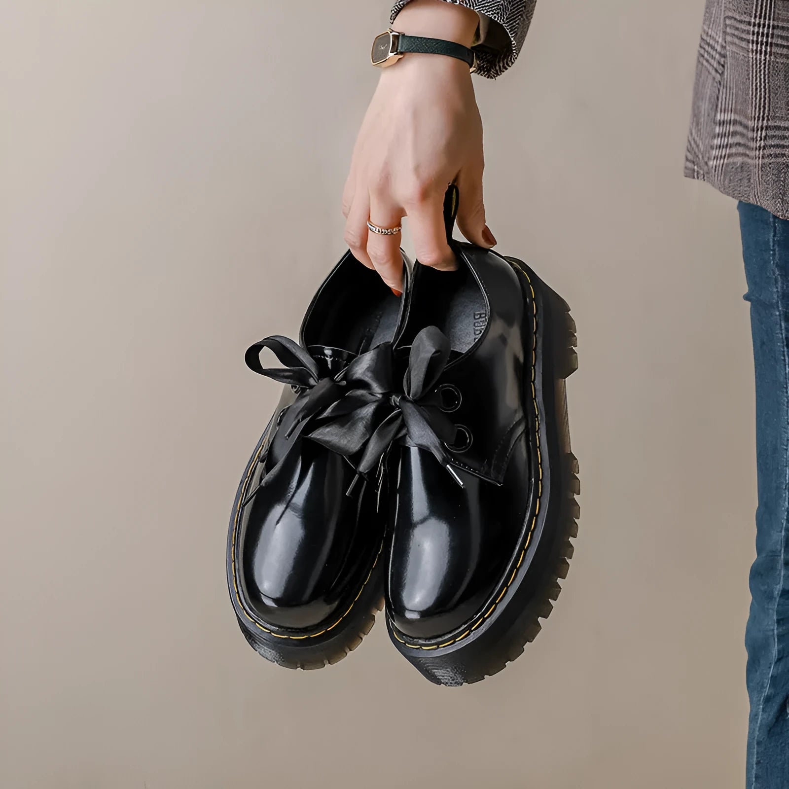 Black thick soled women's lace-up shoes with ribbon and cross strap details on superfine fibre upper