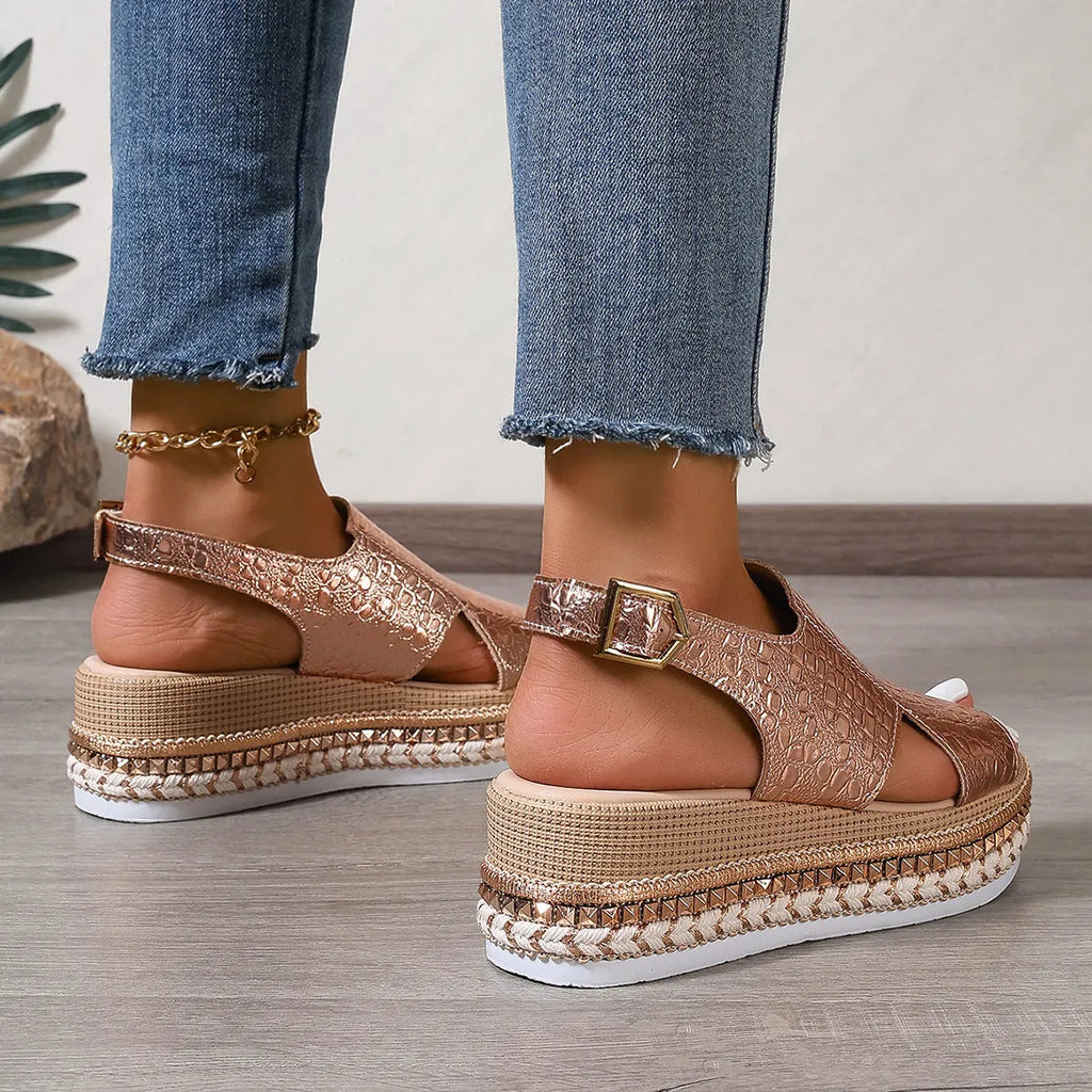 Gold women's Roman sandals with round toe, ankle buckle, and hollow-out design on a rubber sole.