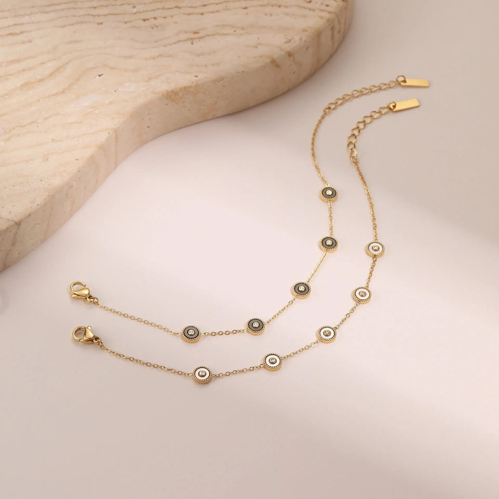 Geometric women's stainless steel bracelet with 18K gold electroplating alongside matching necklace