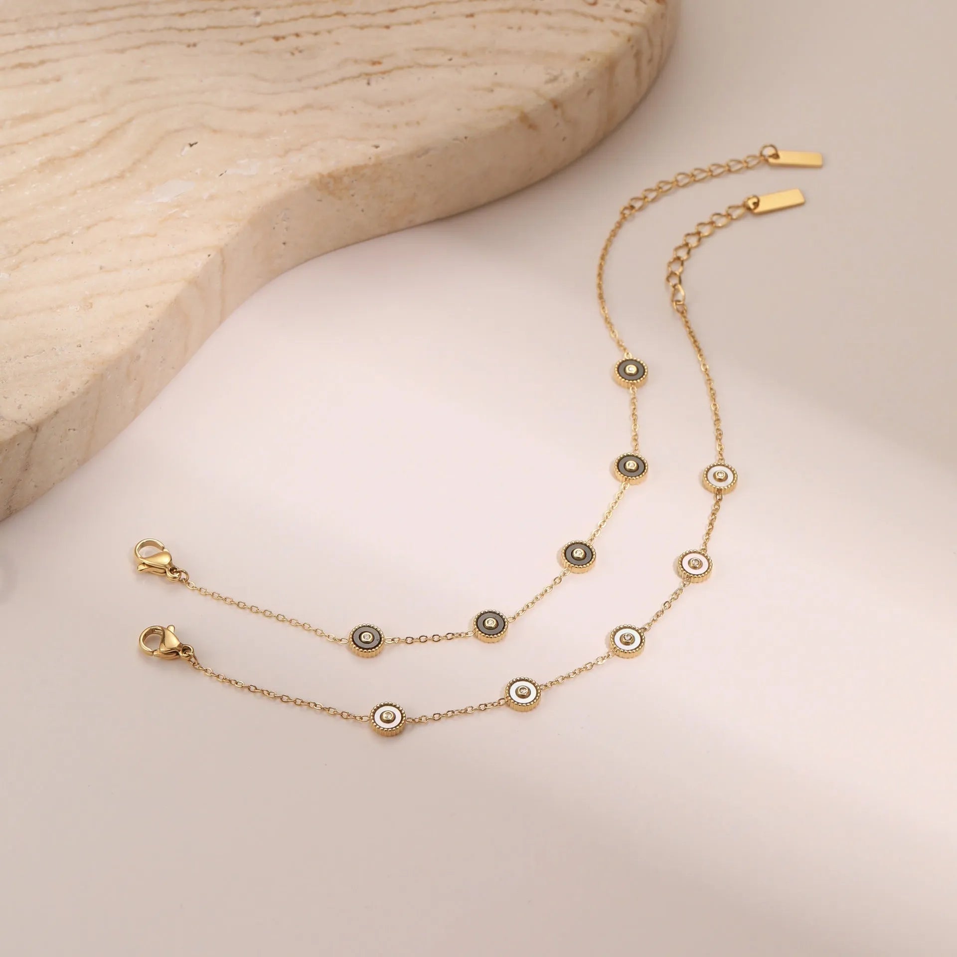 Geometric women's stainless steel bracelet with 18K gold electroplating alongside matching necklace