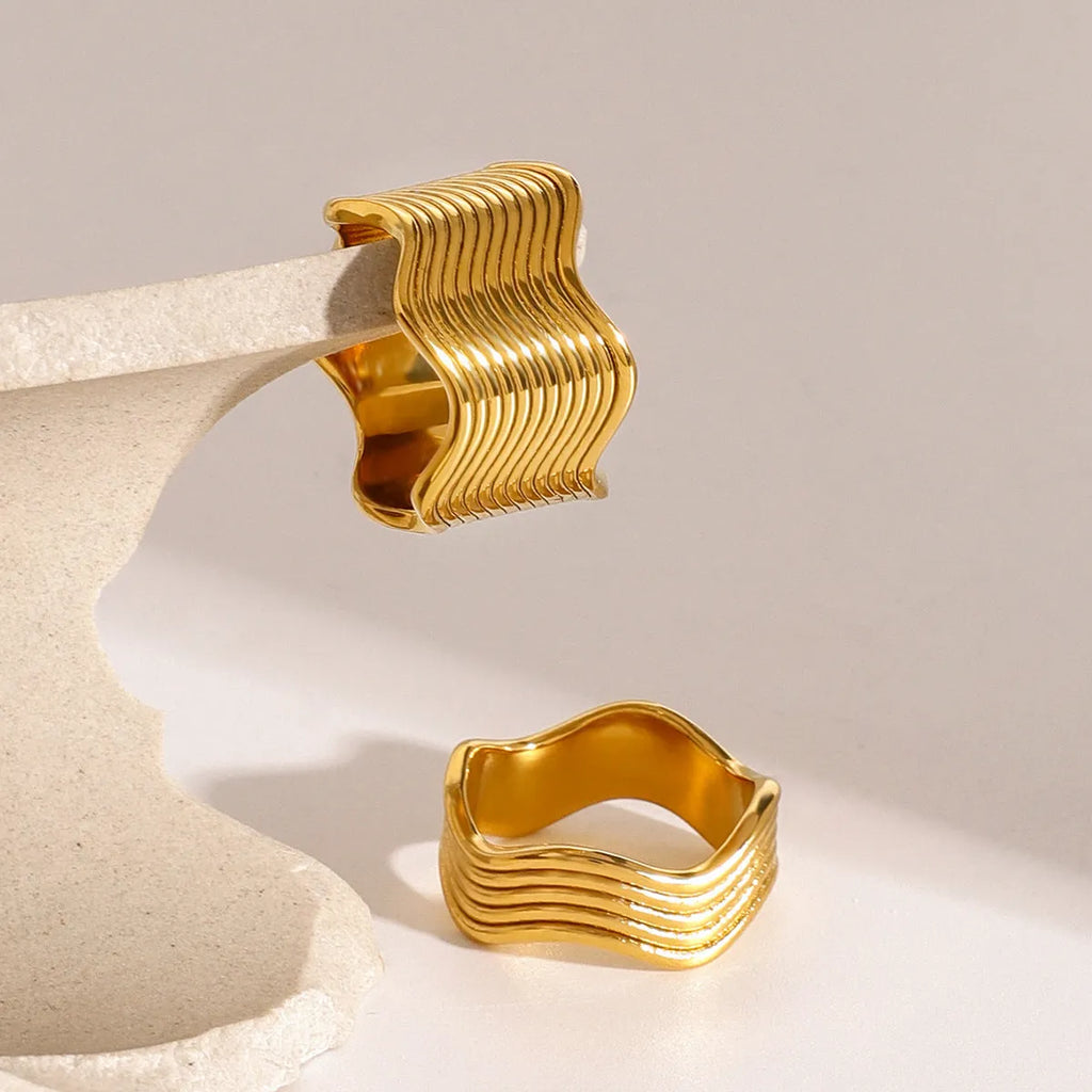 Stainless steel geometric wide band ring with a wave pattern design, shown in an electroplated colour finish.